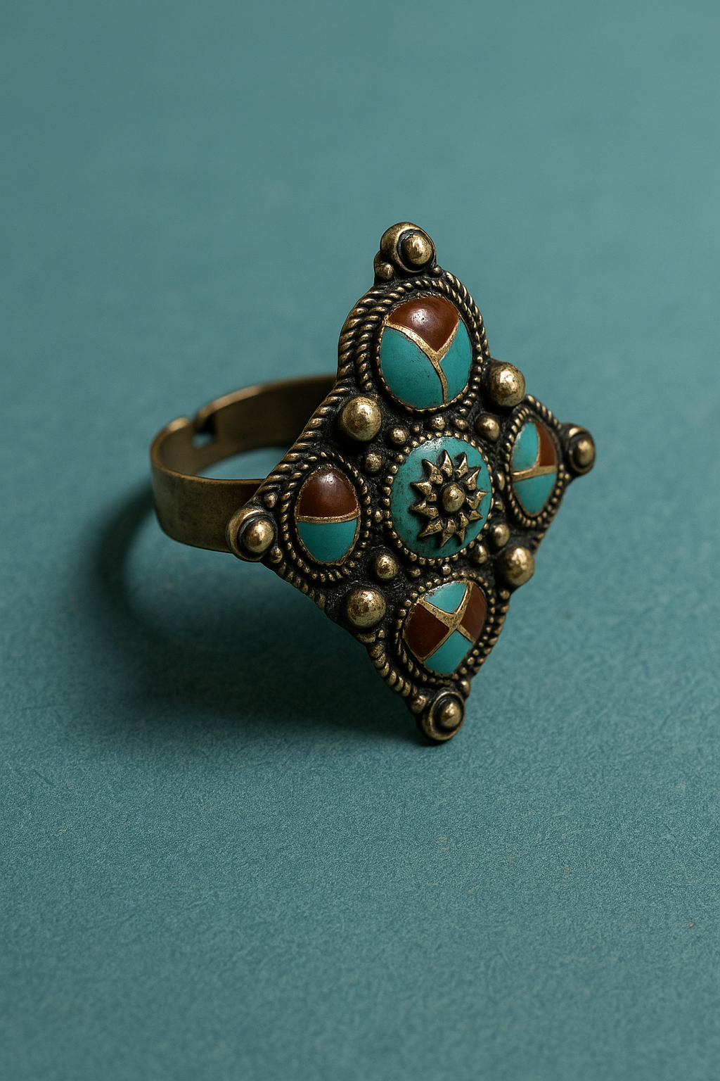 Decorative ring with turquoise and gold accents on a teal background