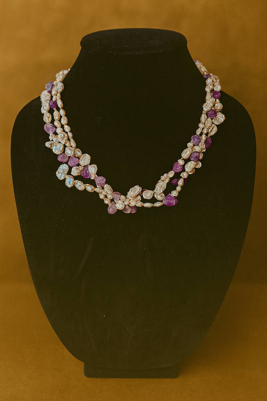 Necklace with purple and white stones on a black mannequin against a brown background