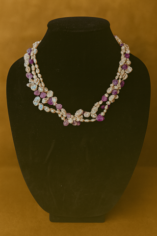 Necklace with purple and white stones on a black mannequin against a brown background