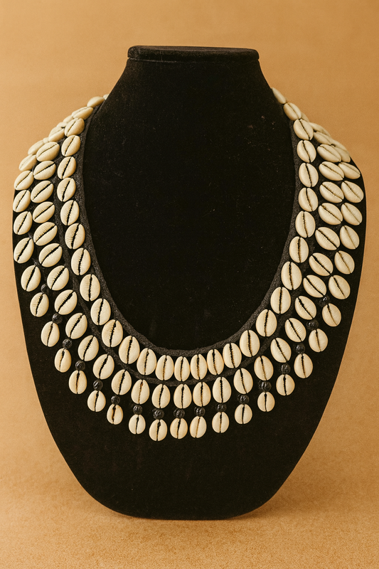 Necklace made of shell-like beads on a black stand against a beige background
