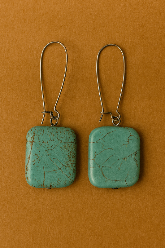 Pair of turquoise square earrings on a brown background